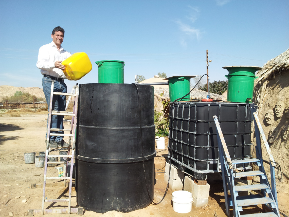 Culhane innoculates the ARTI side of the Solar CITIES IBC/ARTI hybrid with cow manure from the Kibbutz